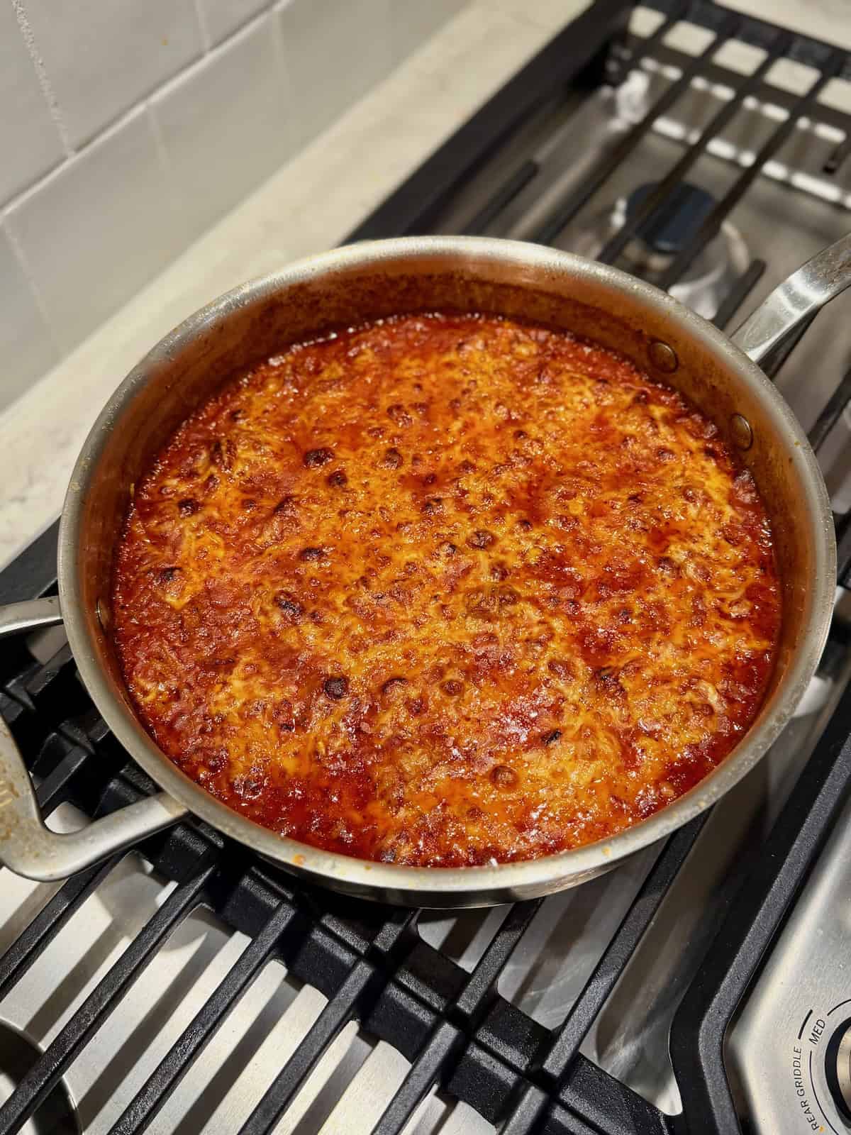 Baked sausage orzo with browned, bubbly cheese just out of the oven.