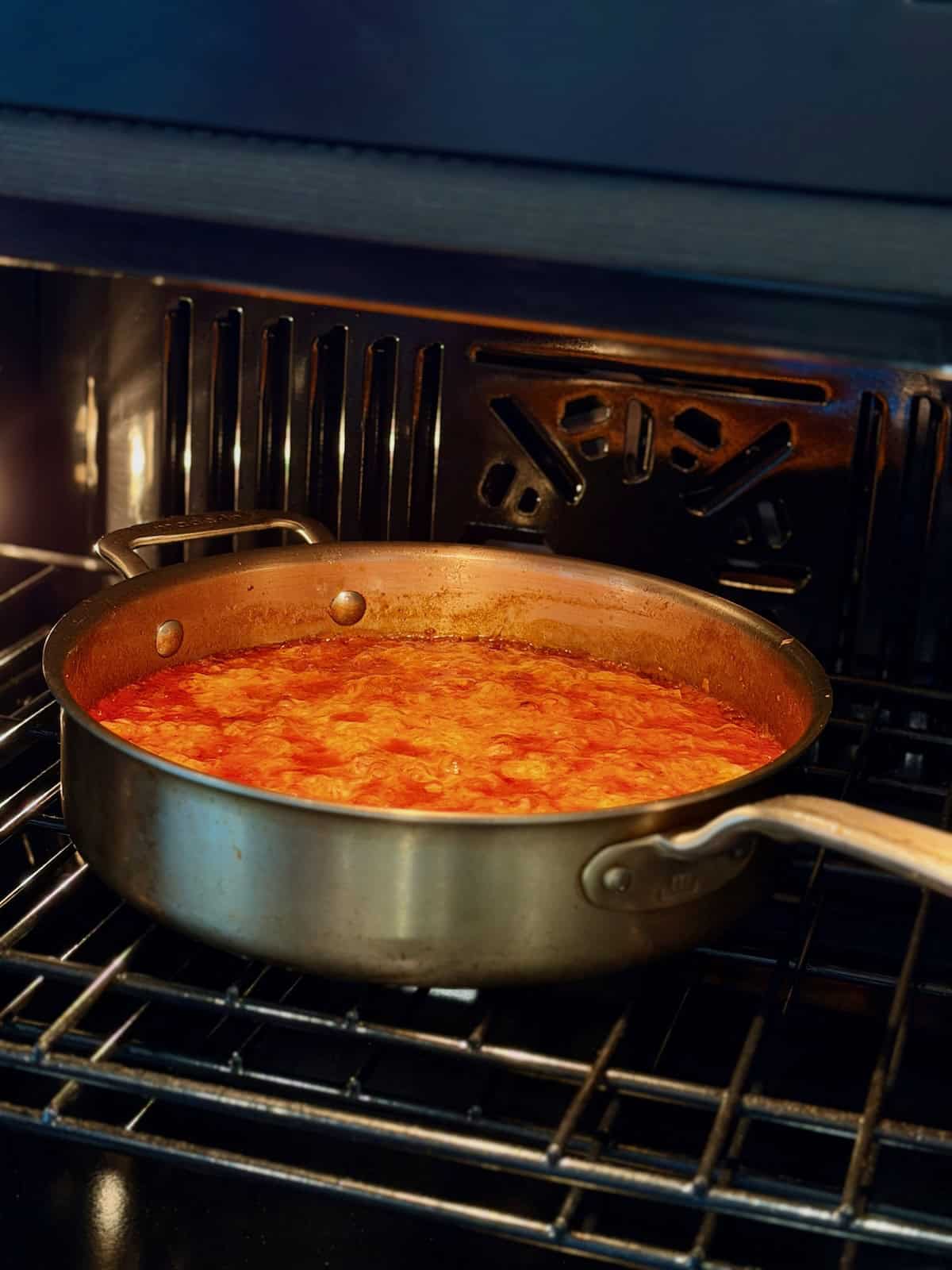 Sausage orzo baking in a pan until the cheese is melted and bubbly.