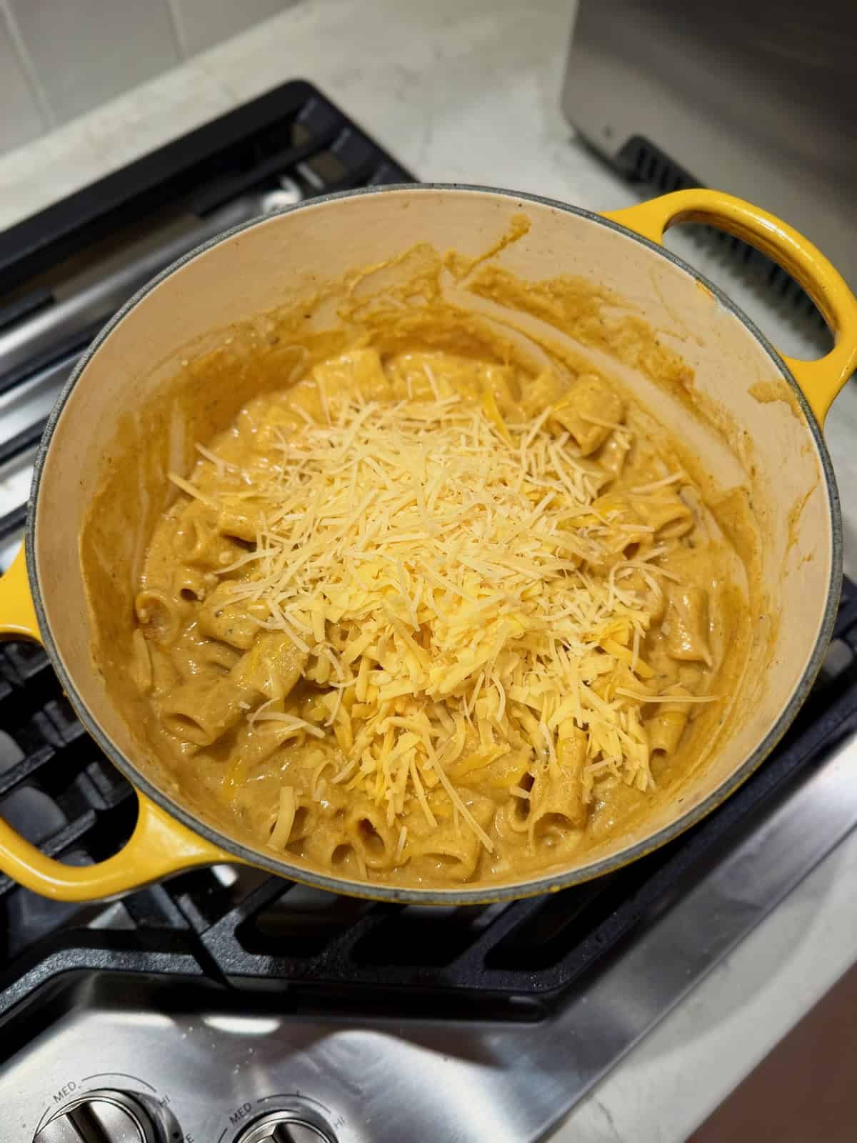 Shredded Gouda, cheddar, and Parmesan are added to the creamy pumpkin pasta.