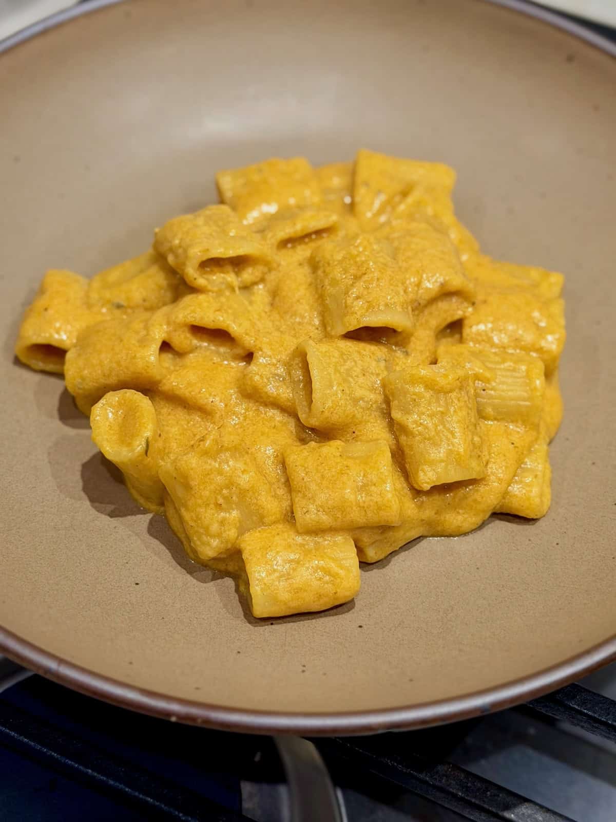 Creamy butternut squash mac and cheese is served in a shallow bowl.