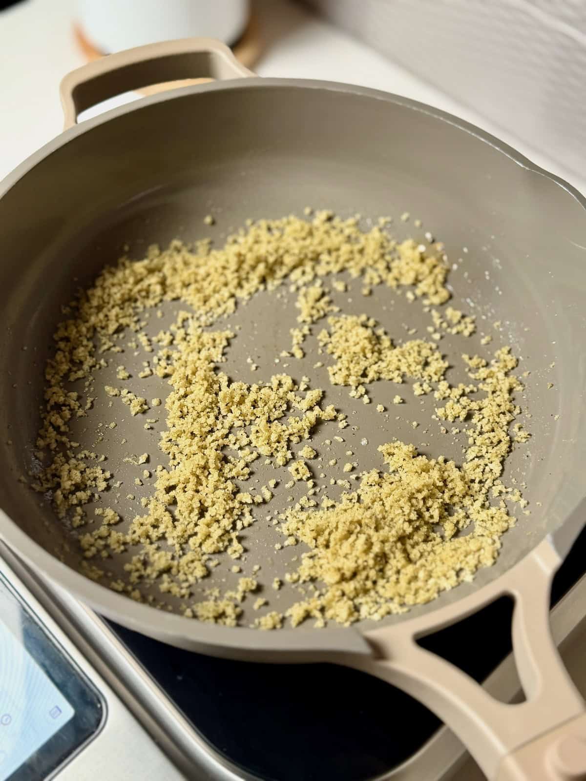 Breadcrumbs cooking in brown butter in a skillet until golden and toasted.