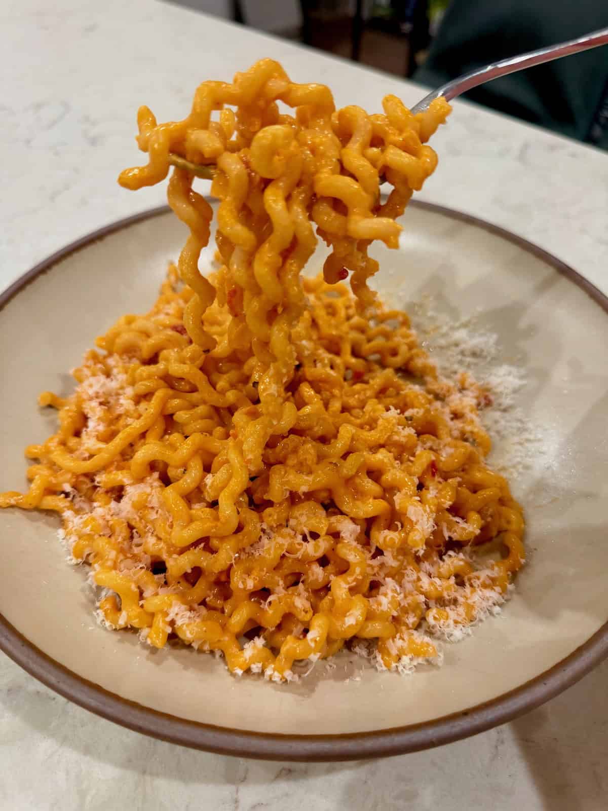 Fork lifting spicy Calabrian chili pasta coated in creamy Calabrian chili sauce.