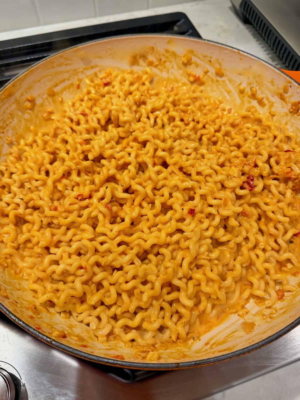 Fusilli col buco tossed in creamy Calabrian chili sauce until evenly coated.
