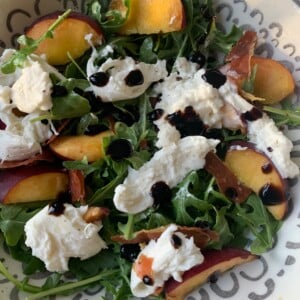 Arugula salad with peaches, crispy prosciutto, and burrata