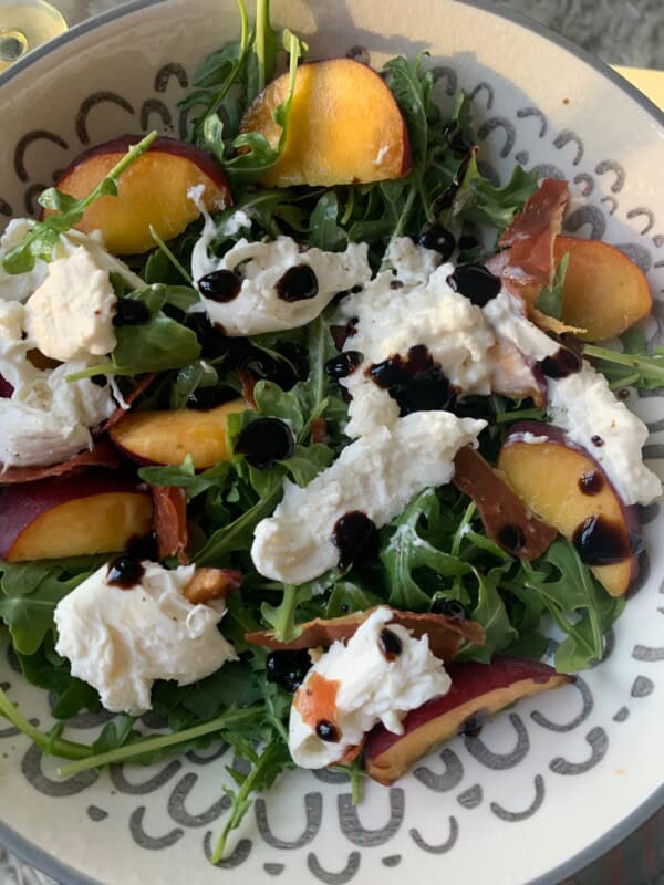 Arugula salad with peaches, crispy prosciutto, and burrata