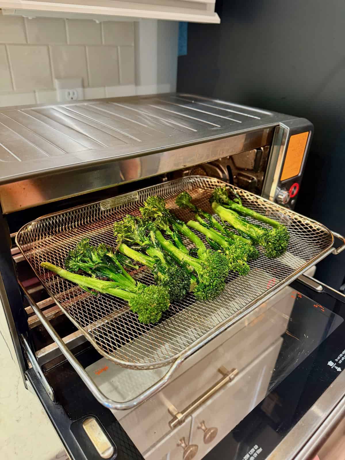 Baby broccoli cooks in the air fryer until tender and lightly charred.