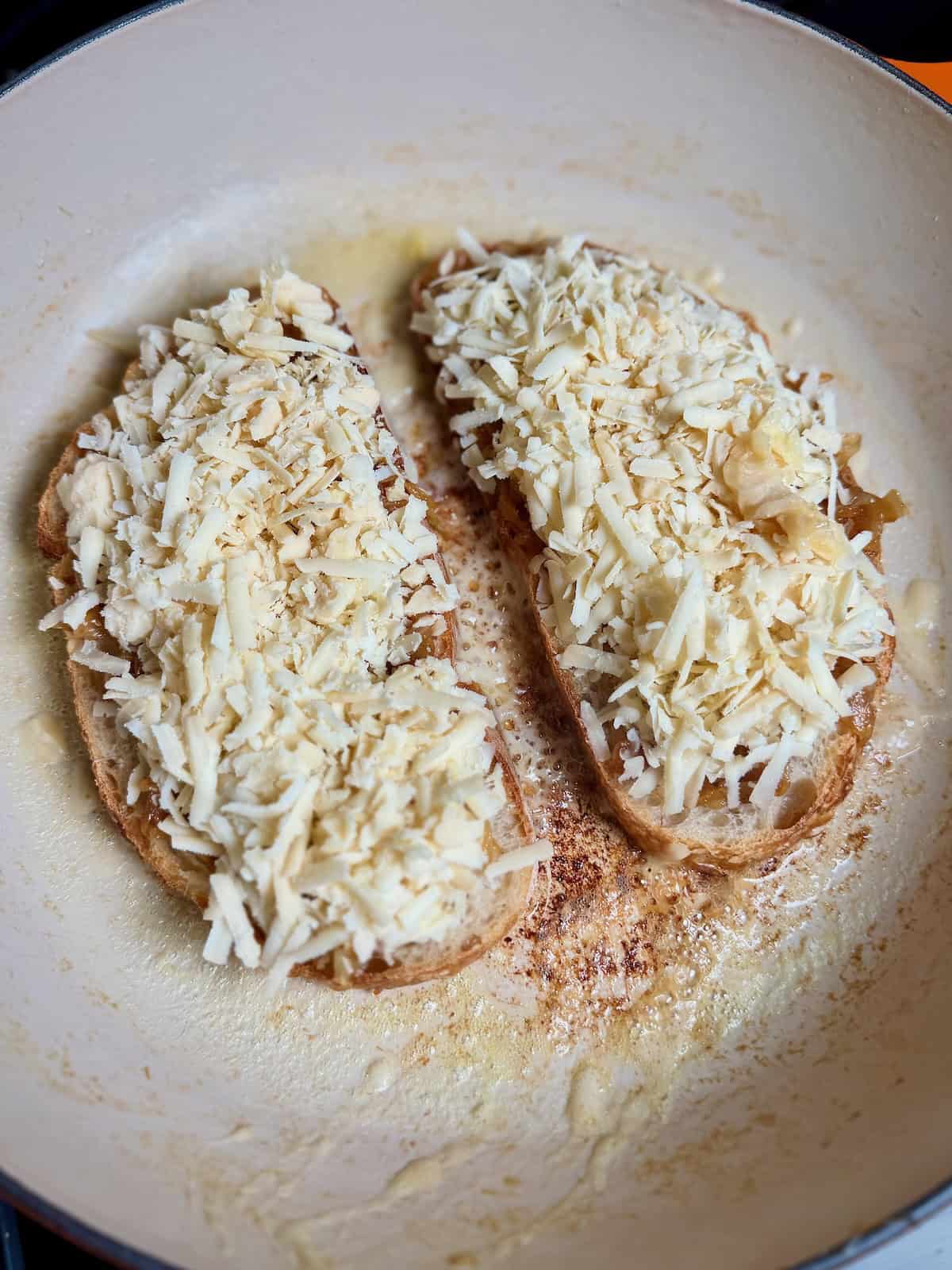 Shredded cheese added on top of caramelized onions for grilled cheese.