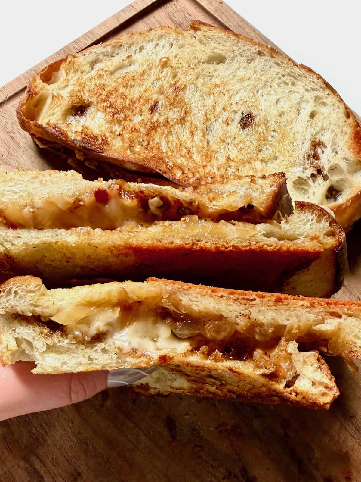 Caramelized onion grilled cheese with melted cheese and golden bread.