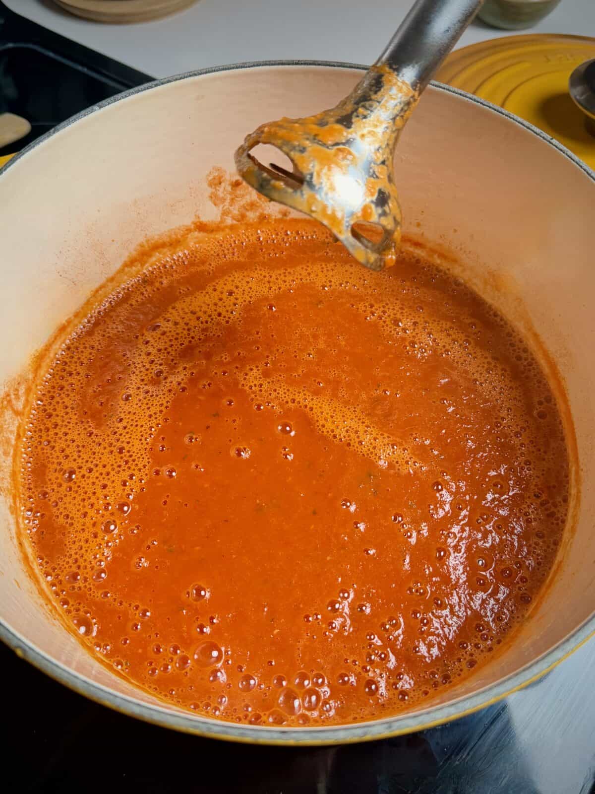Easy tomato soup simmering in a pot after immersion blending.