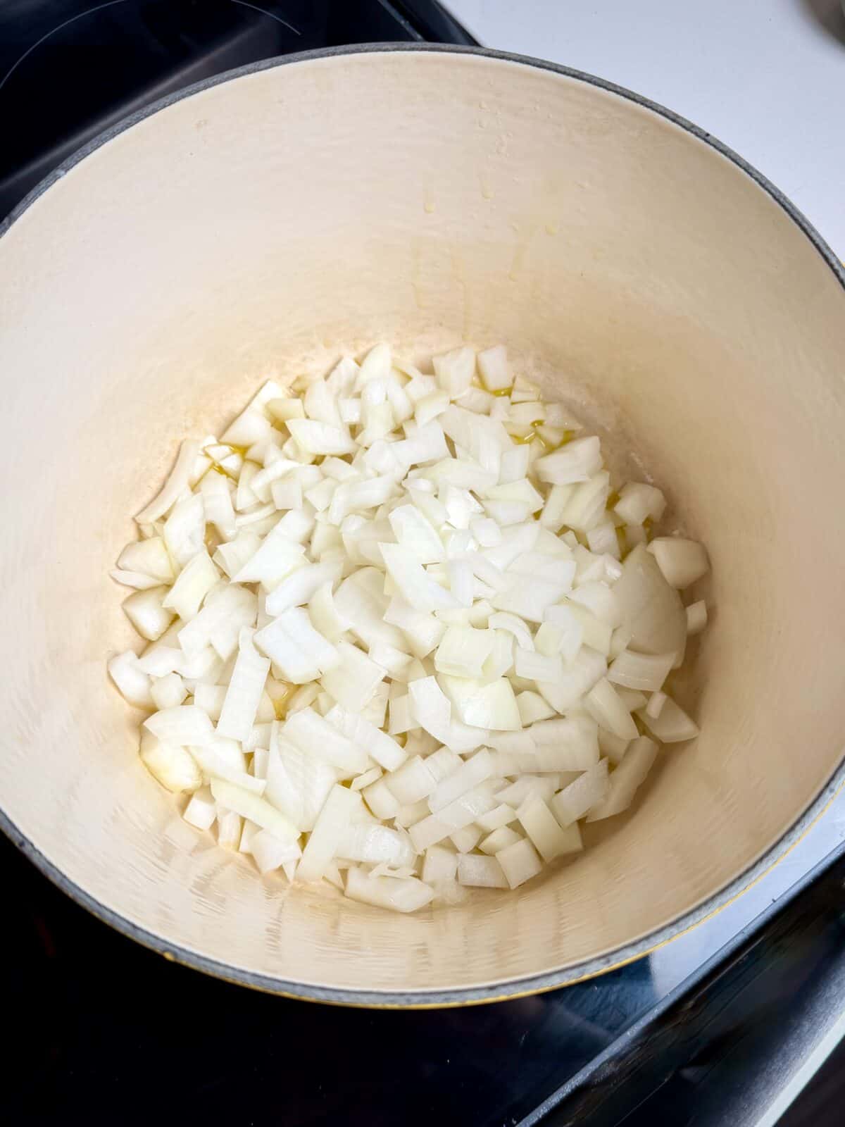 Chopped onion and garlic sautéing in a pot to start easy tomato soup.