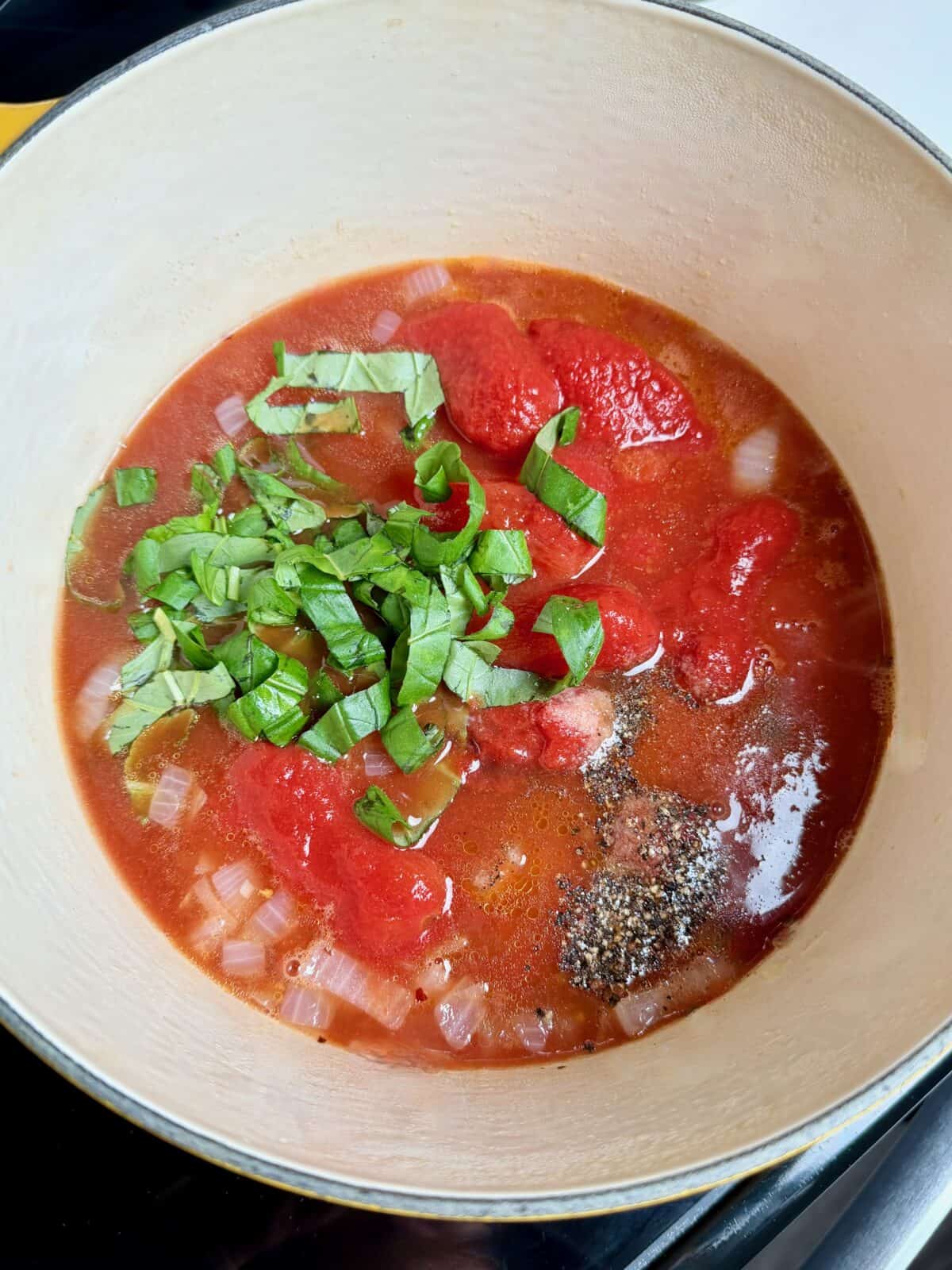 Canned tomatoes and fresh herbs added to the pot for easy tomato soup.