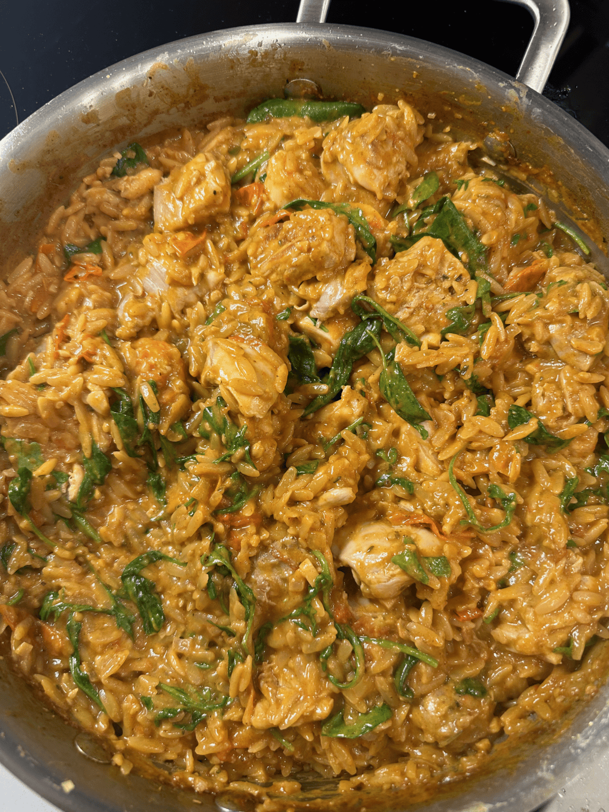 A metal pan with one pan creamy tomato chicken boursin orzo.