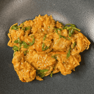 A bowl with one pan creamy tomato chicken boursin orzo.