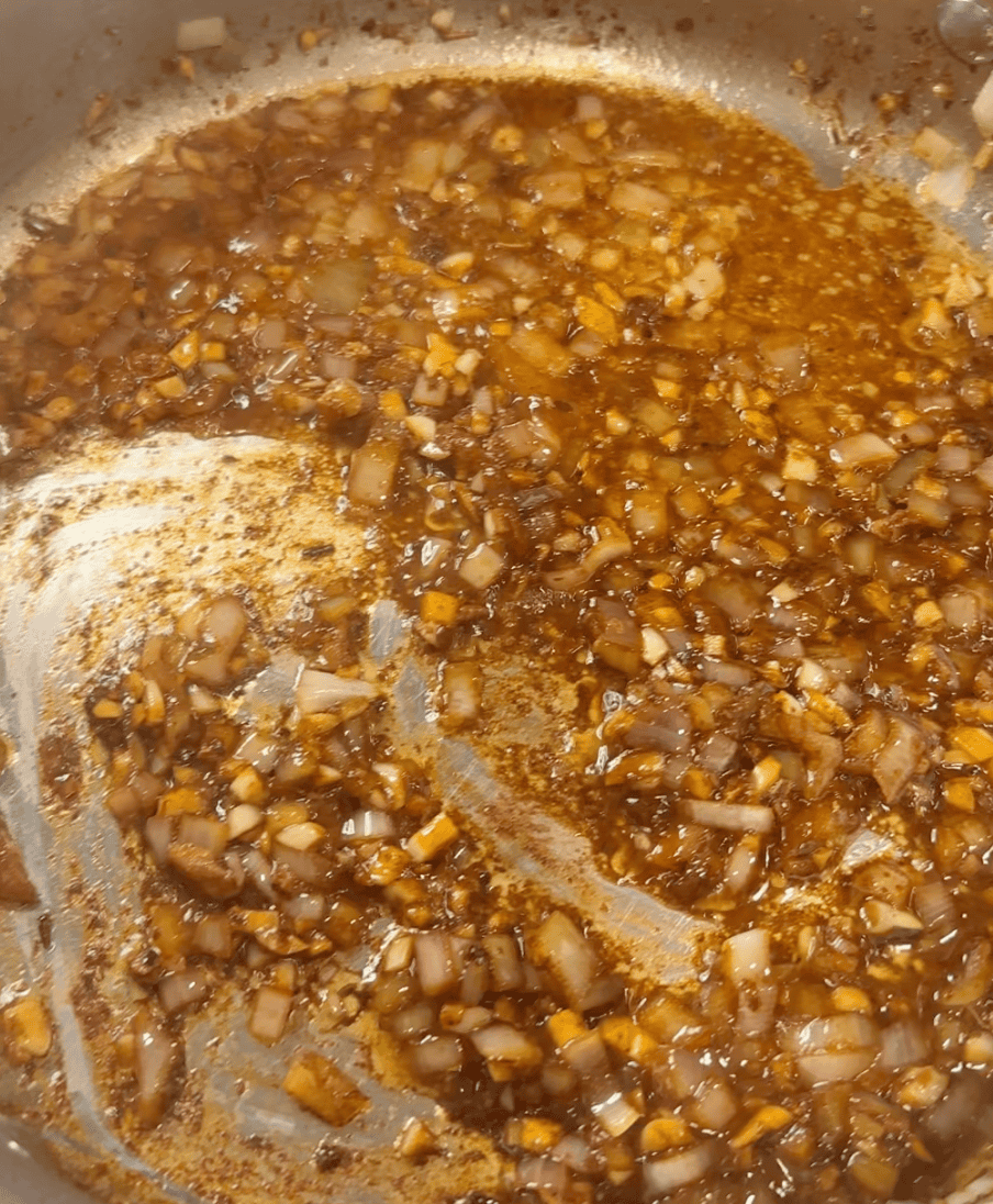 A pan with cooked shallots and garlic.