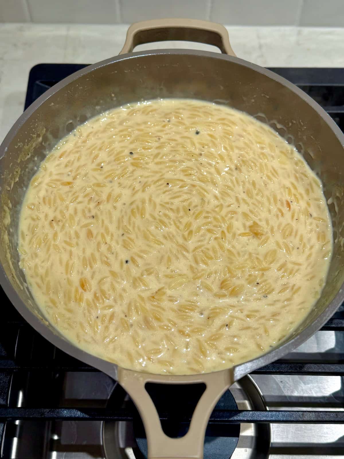 The finished orzo mac and cheese is creamy and thick in the skillet.
