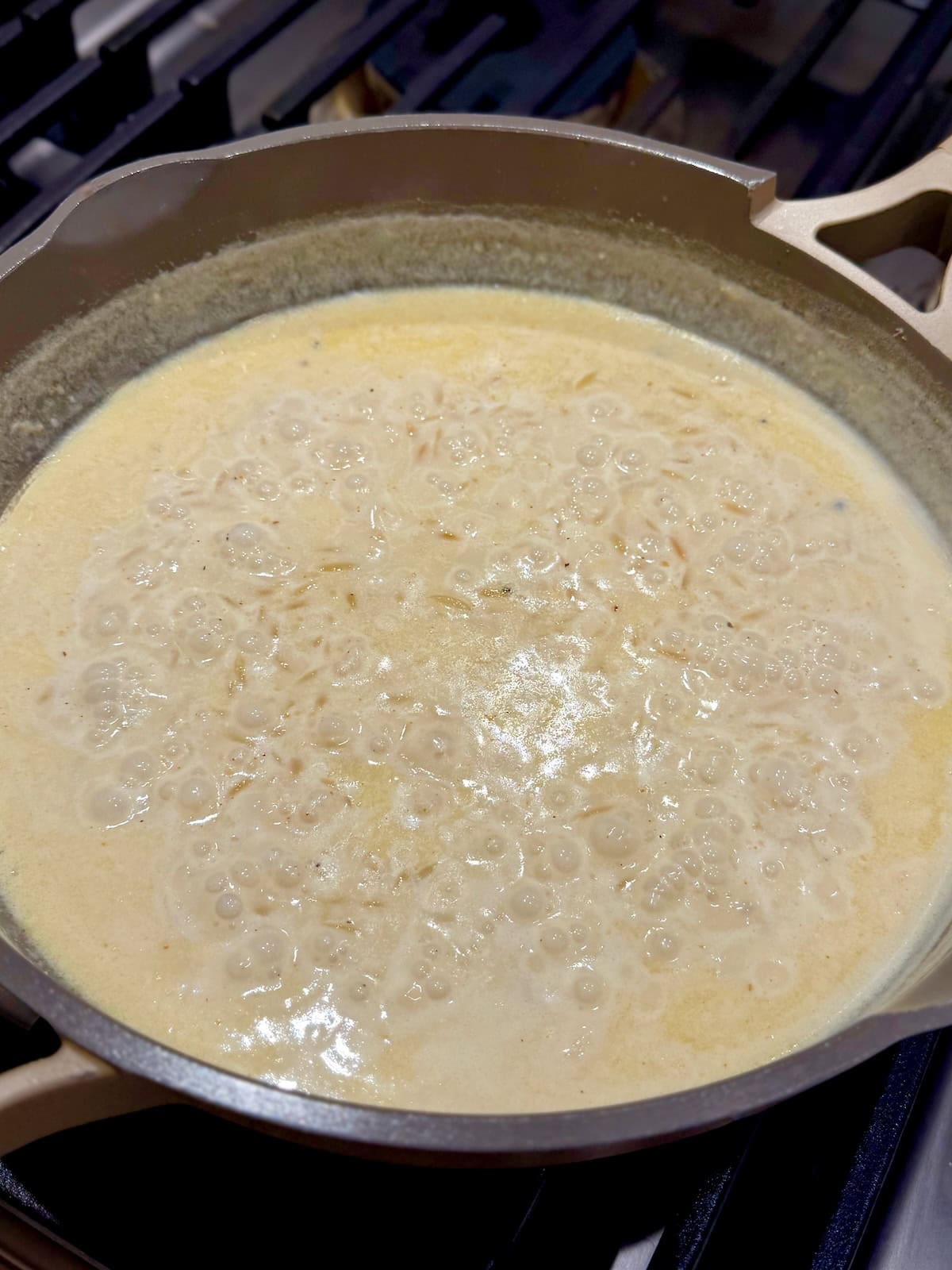 The toasted orzo simmers in a creamy sauce until tender.