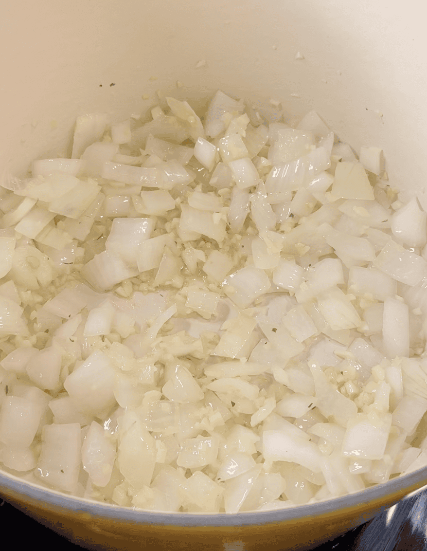 Ginger, onion, and garlic cooking in a dutch oven.
