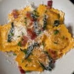 A white bowl with butternut squash ravioli