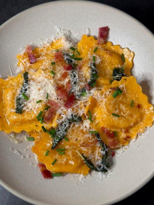A white bowl with butternut squash ravioli
