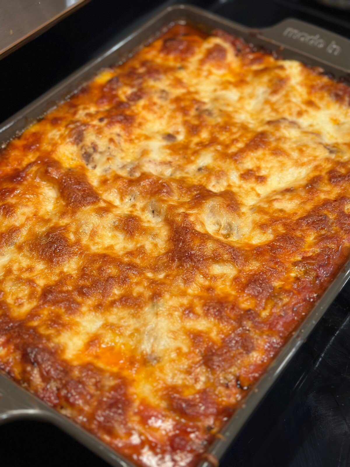 A baking dish with broiled cheesy lasagna