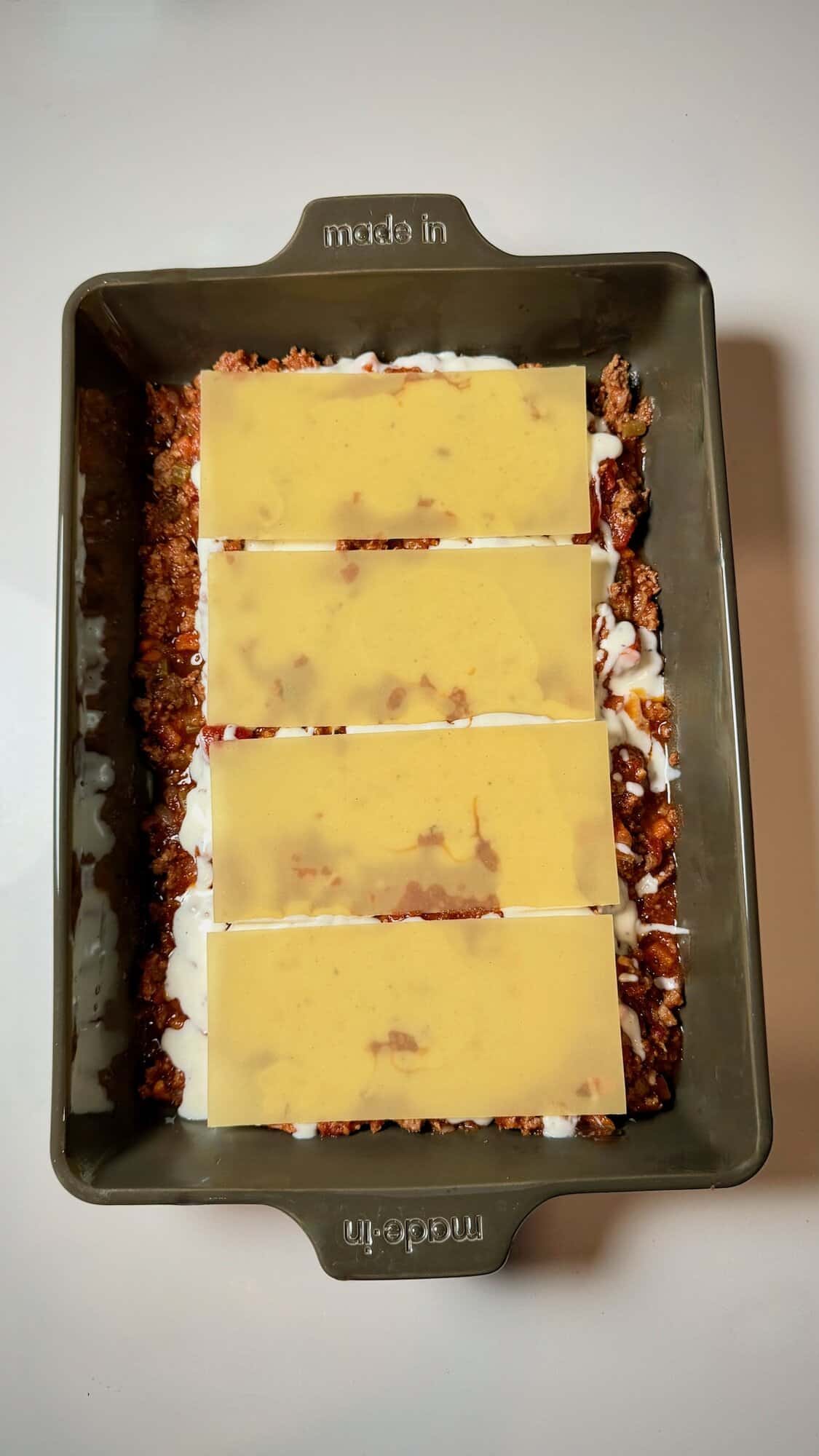 Lasagna noodles arranged evenly in baking dish.