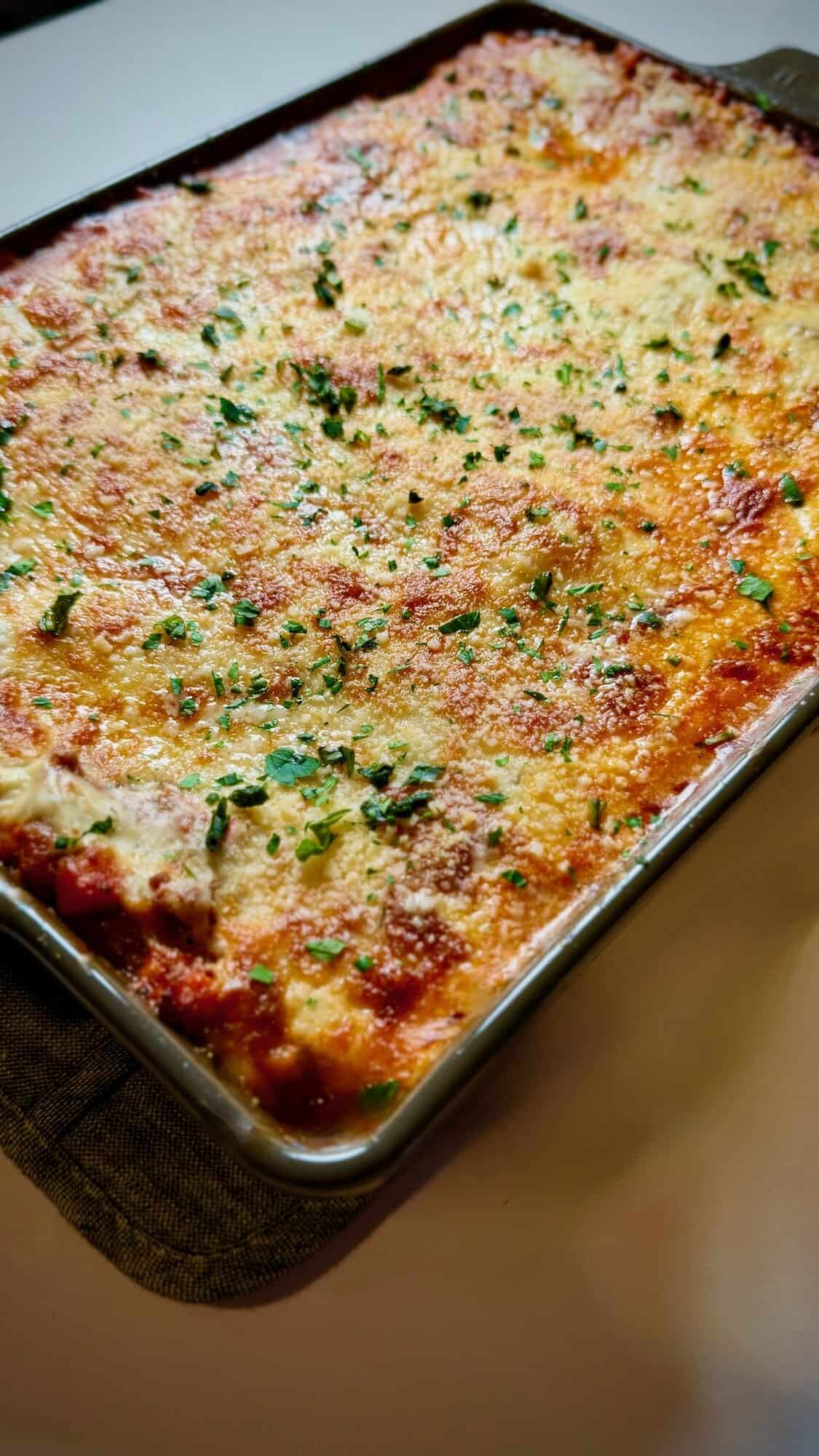 Lasagna with béchamel and golden baked top in pan.