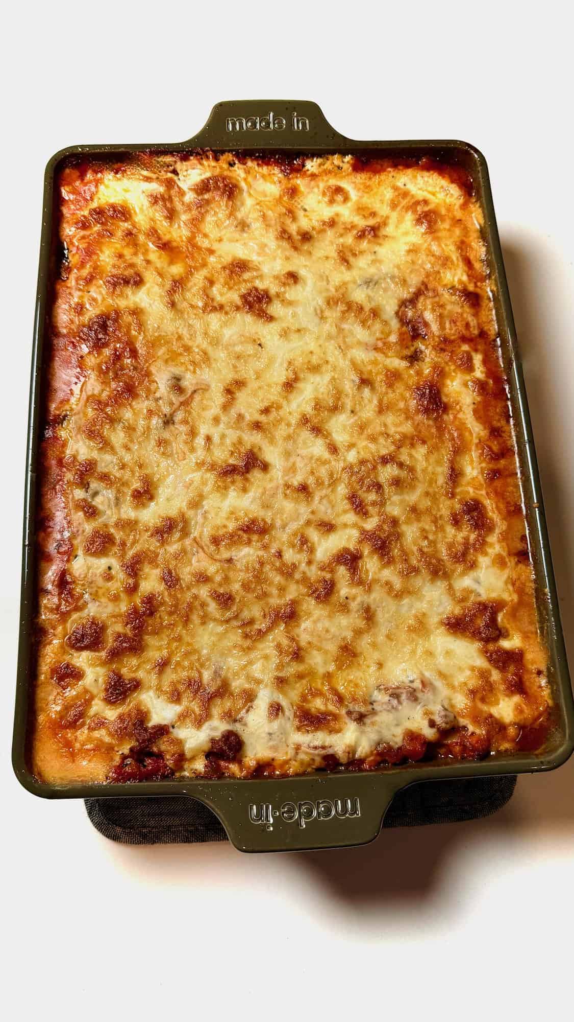 Baked lasagna with béchamel sauce in pan.