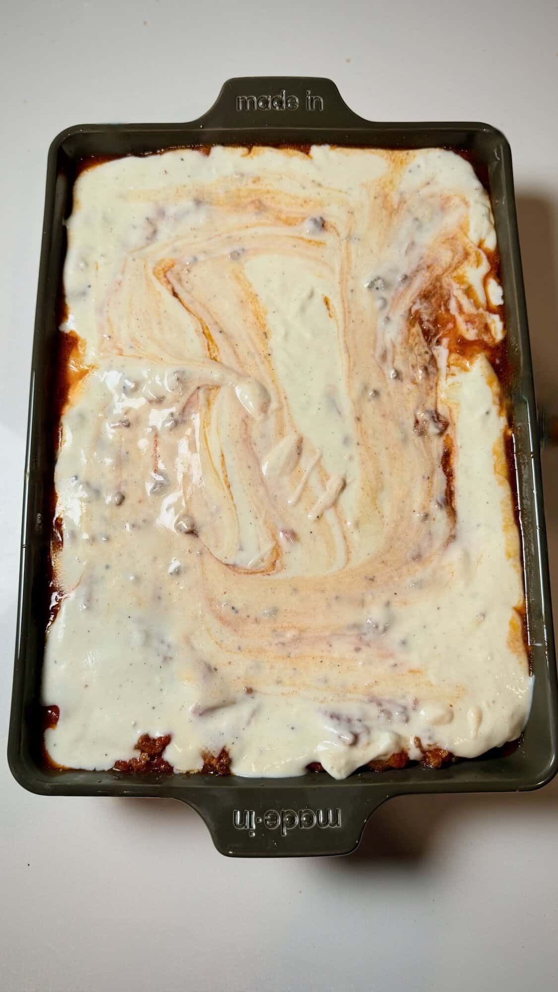Lasagna with béchamel spread evenly over top layer.
