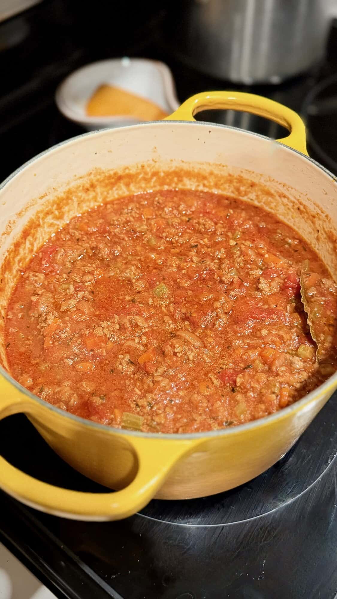 Meat sauce simmering in Dutch oven for lasagna.