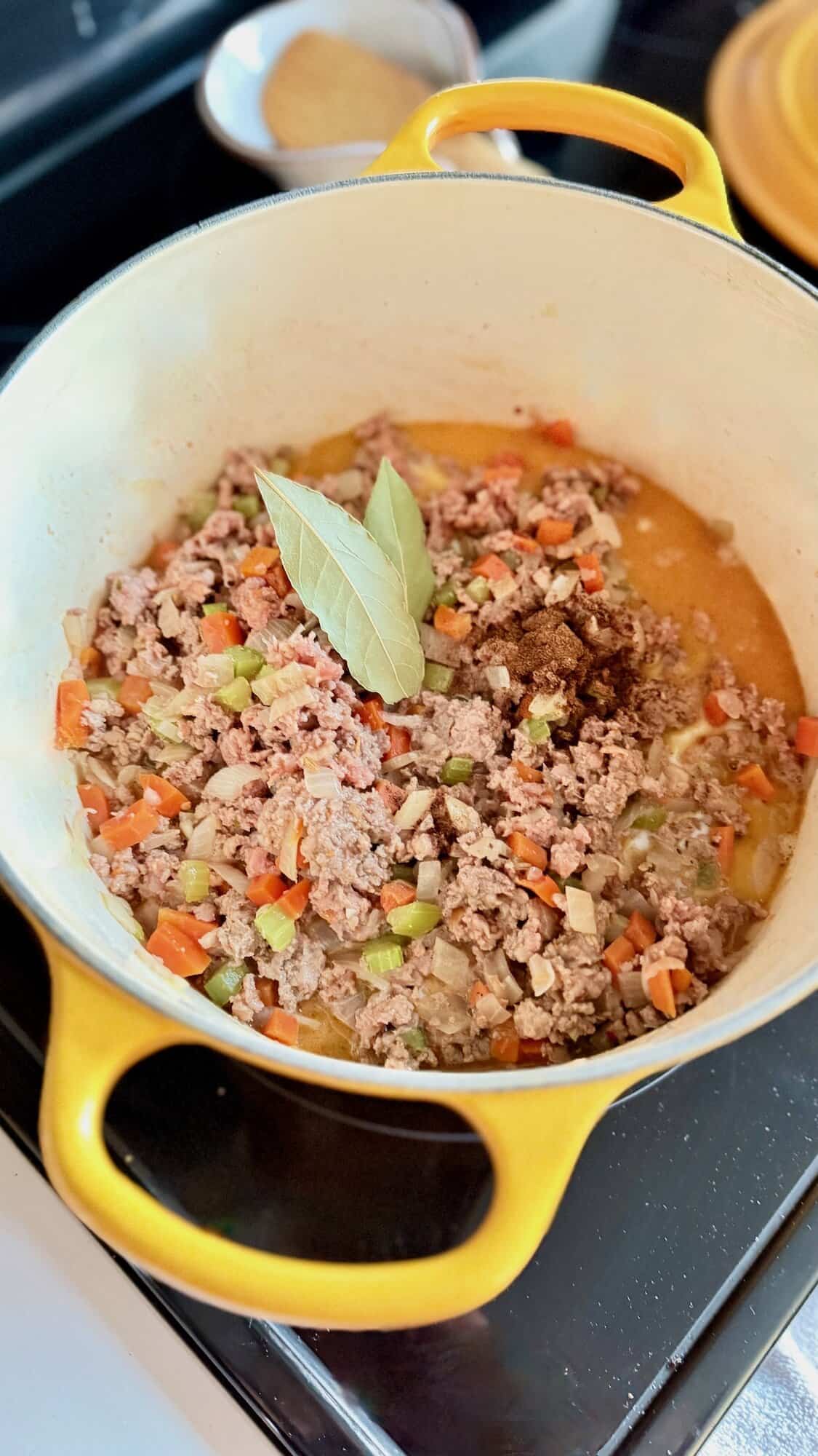 Meat sauce with vegetables cooking in Dutch oven.