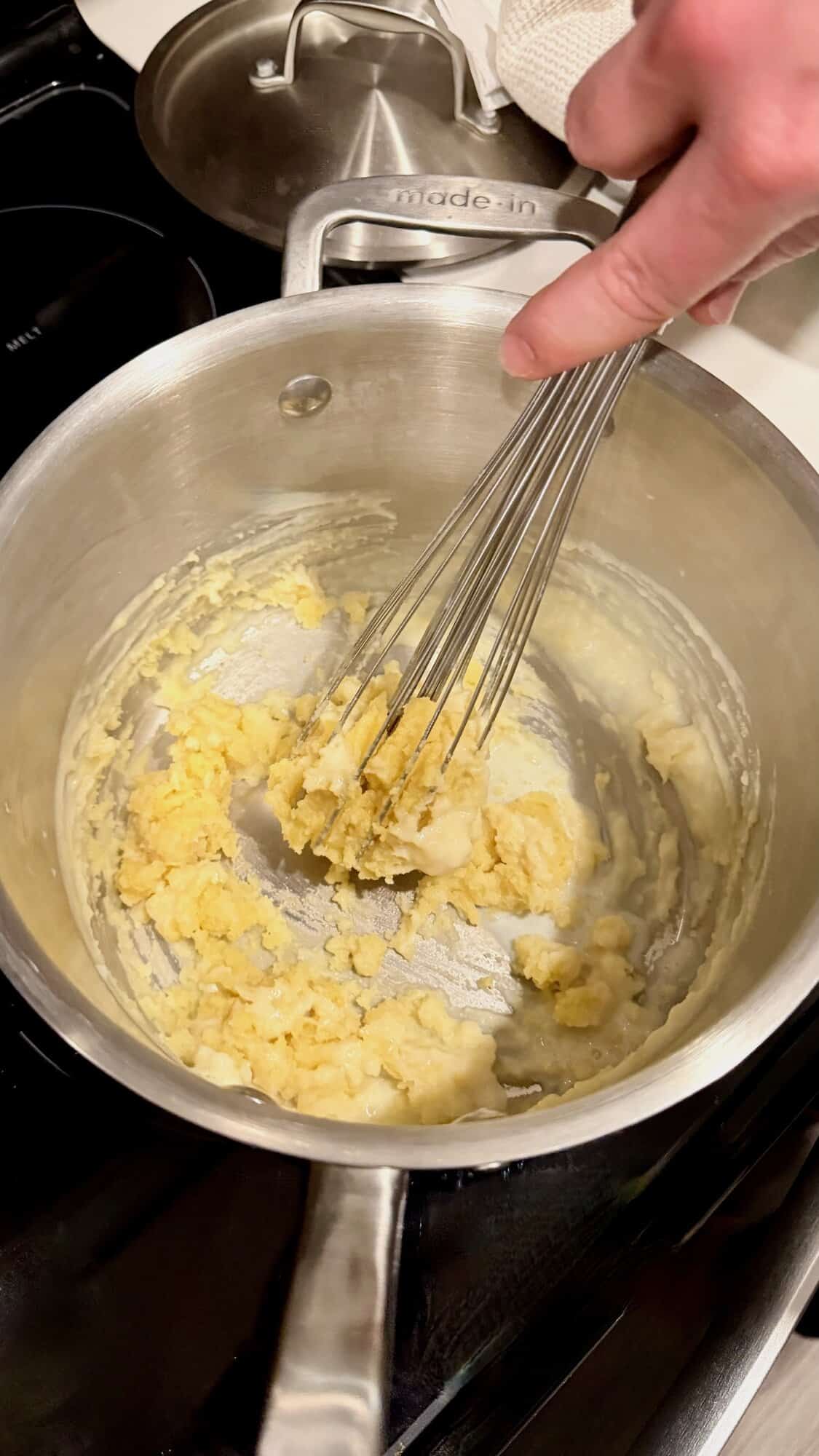 Whisking melted butter and flour for béchamel sauce.