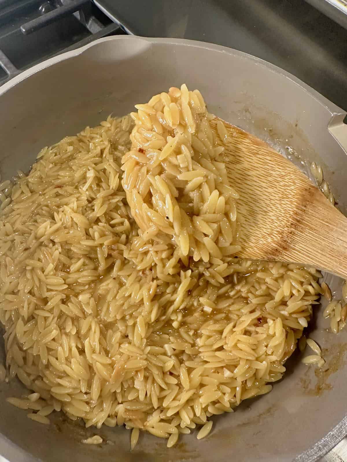 Lemon Orzo in Pan on Wooden Spoon
