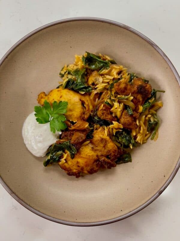 Chicken shawarma on top of orzo with yogurt sauce.