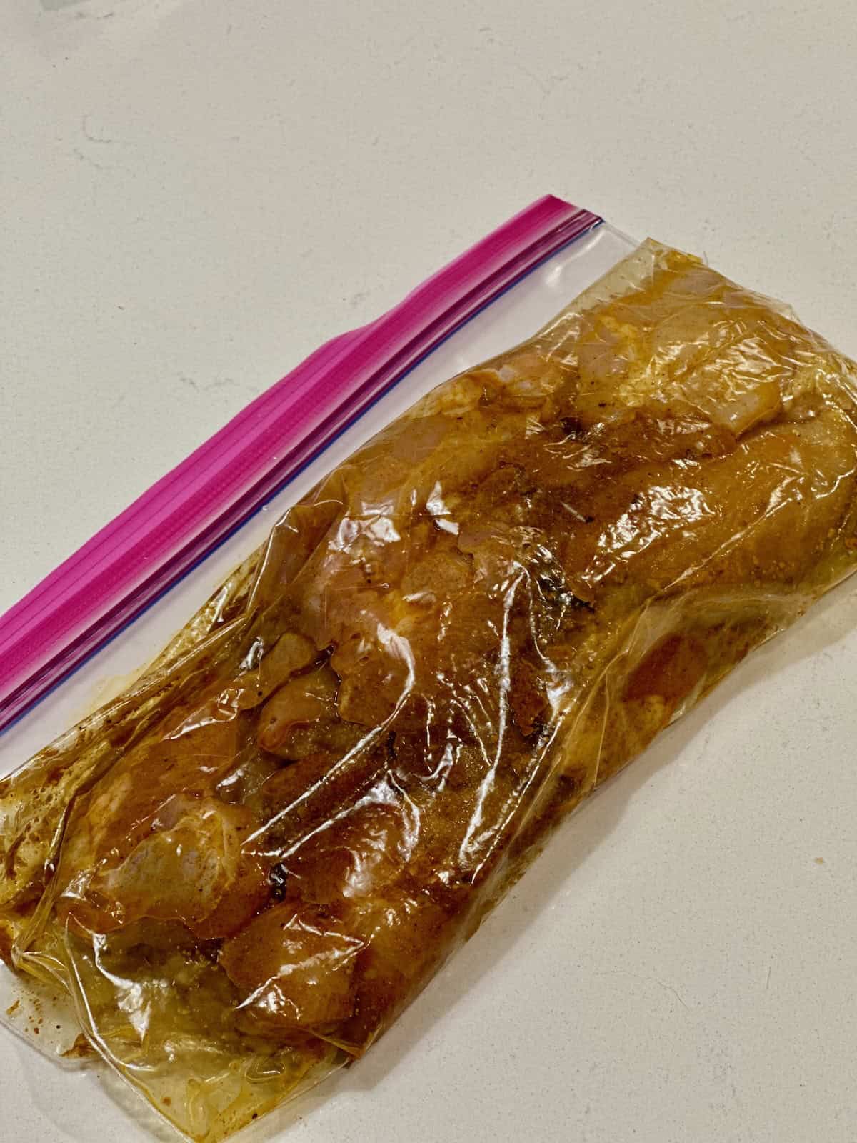 Chicken thighs marinating in shawarma spices for chicken shawarma orzo.