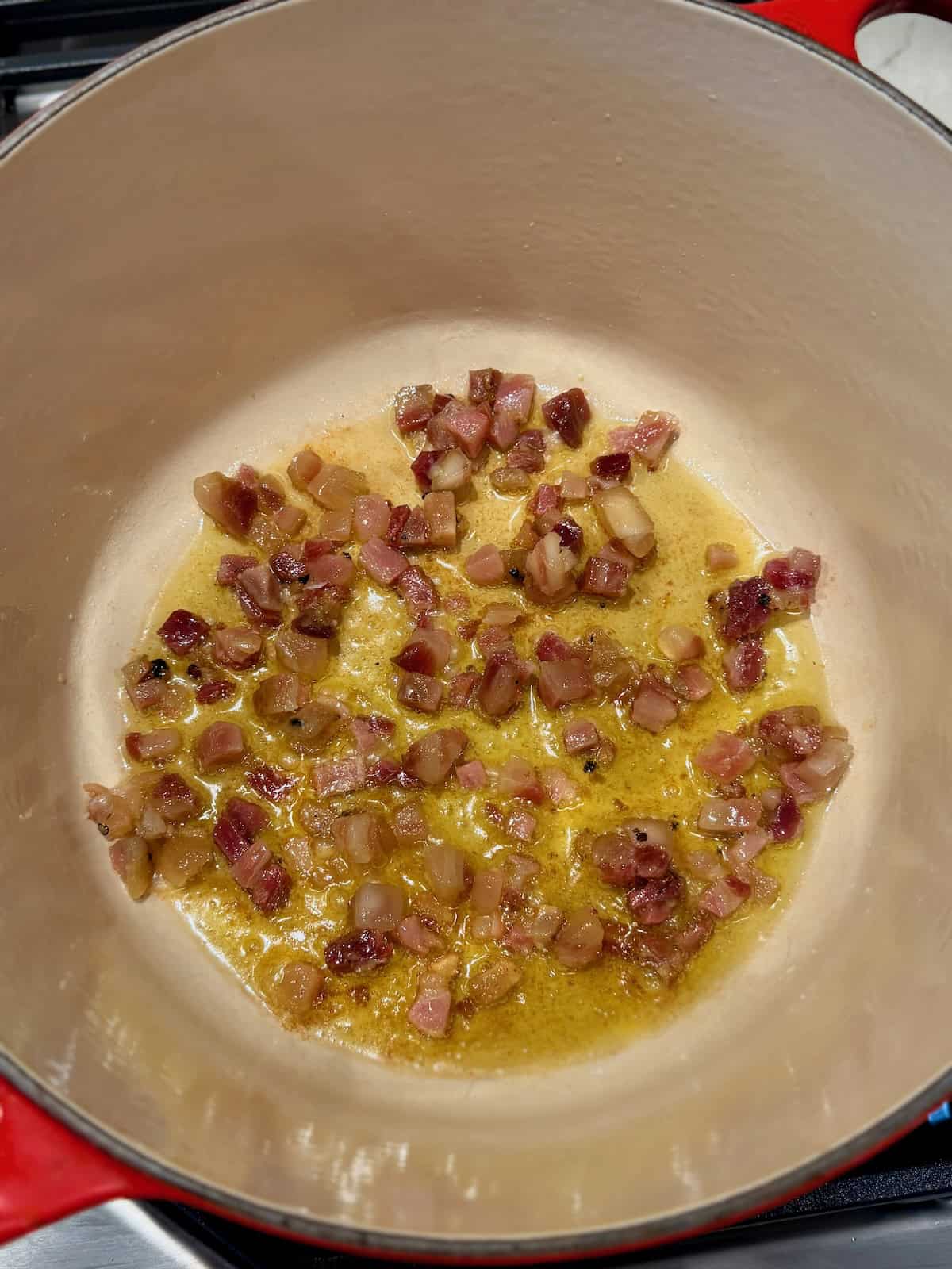 Diced pancetta cooks in a Dutch oven as its fat renders.