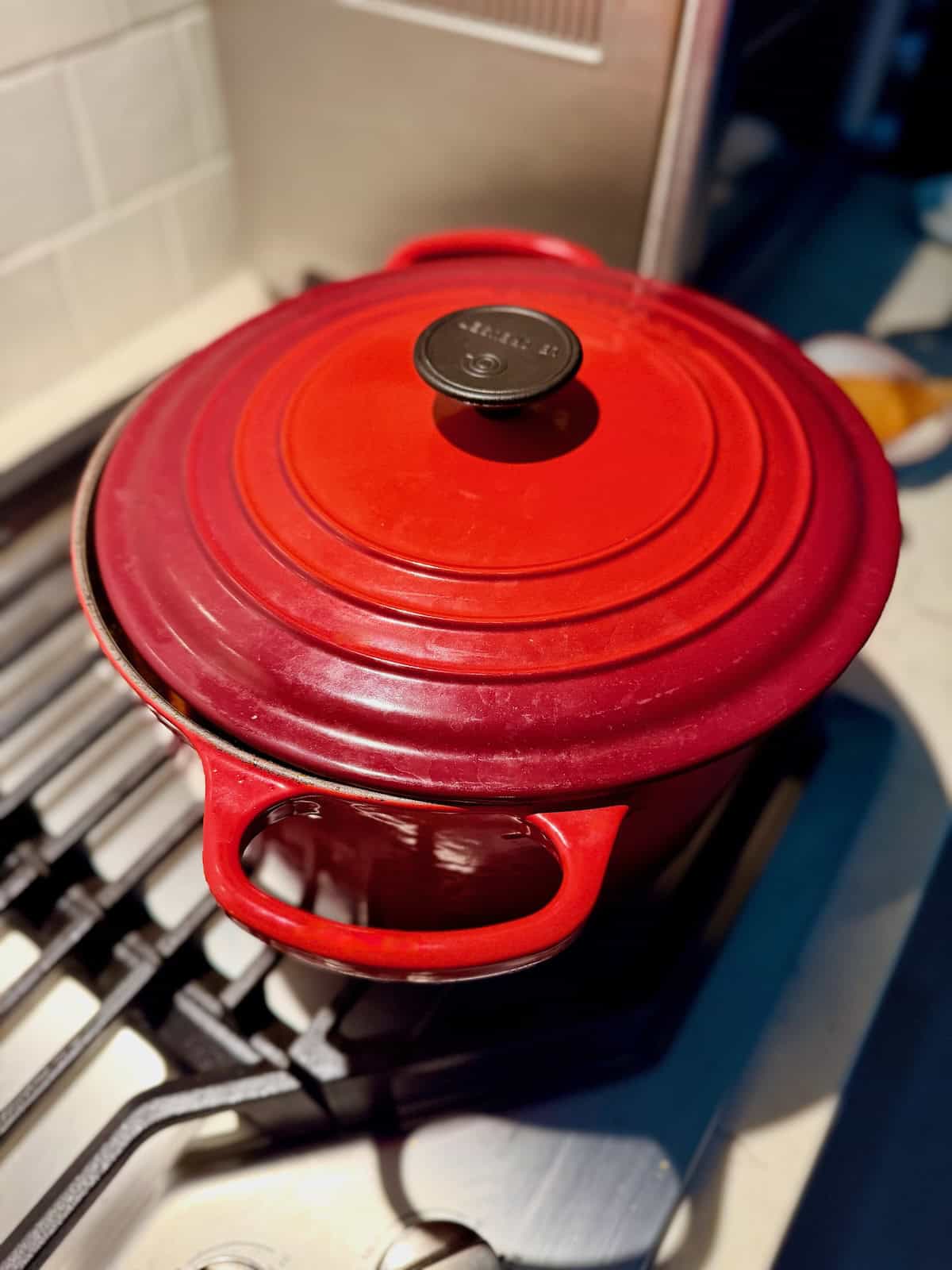 A red Dutch oven is covered while the Chinese-Italian Ragu slowly simmers.