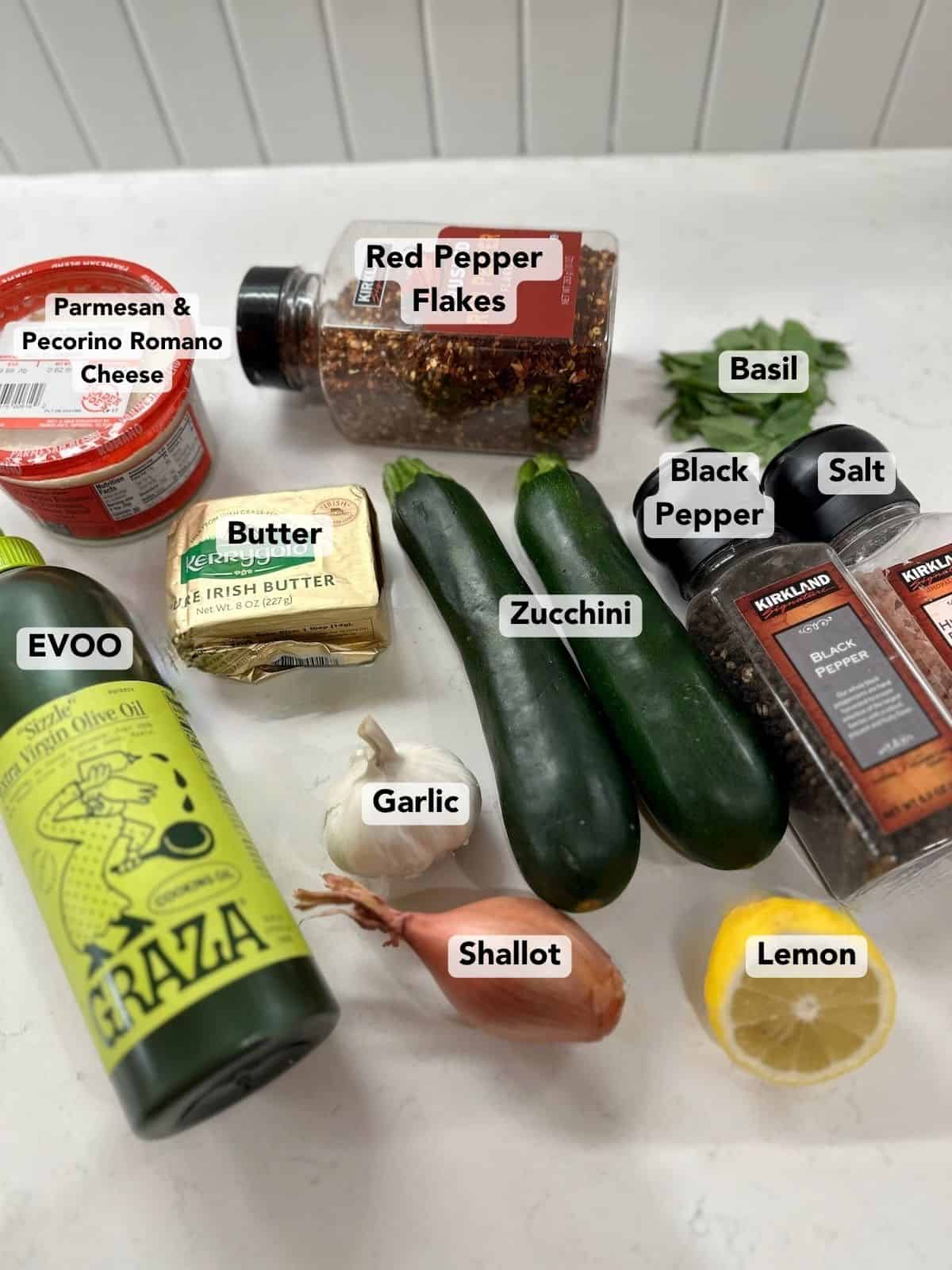 Ingredients for creamy zucchini pasta including zucchini, garlic, shallot, Parmesan, Pecorino Romano, lemon, and basil.