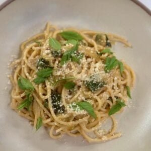 Creamy zucchini pasta topped with grated cheese and fresh basil.