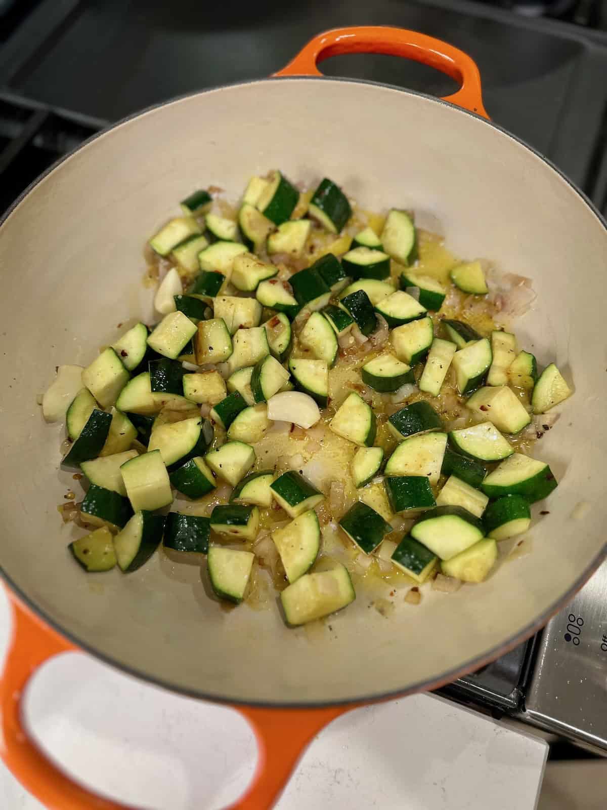 Zucchini slowly cooking until soft and jammy.