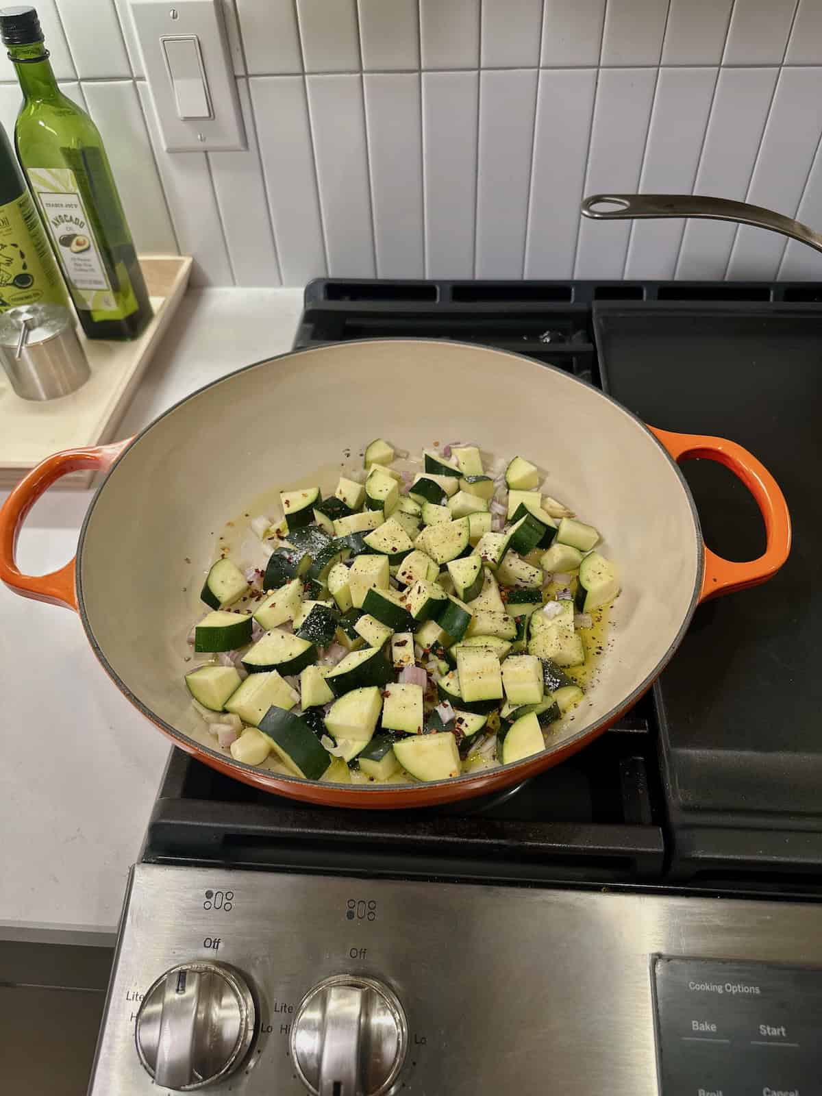 Diced zucchini, garlic, and shallot cooking in olive oil.