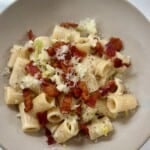 White bowl with leek and bacon creamy pasta