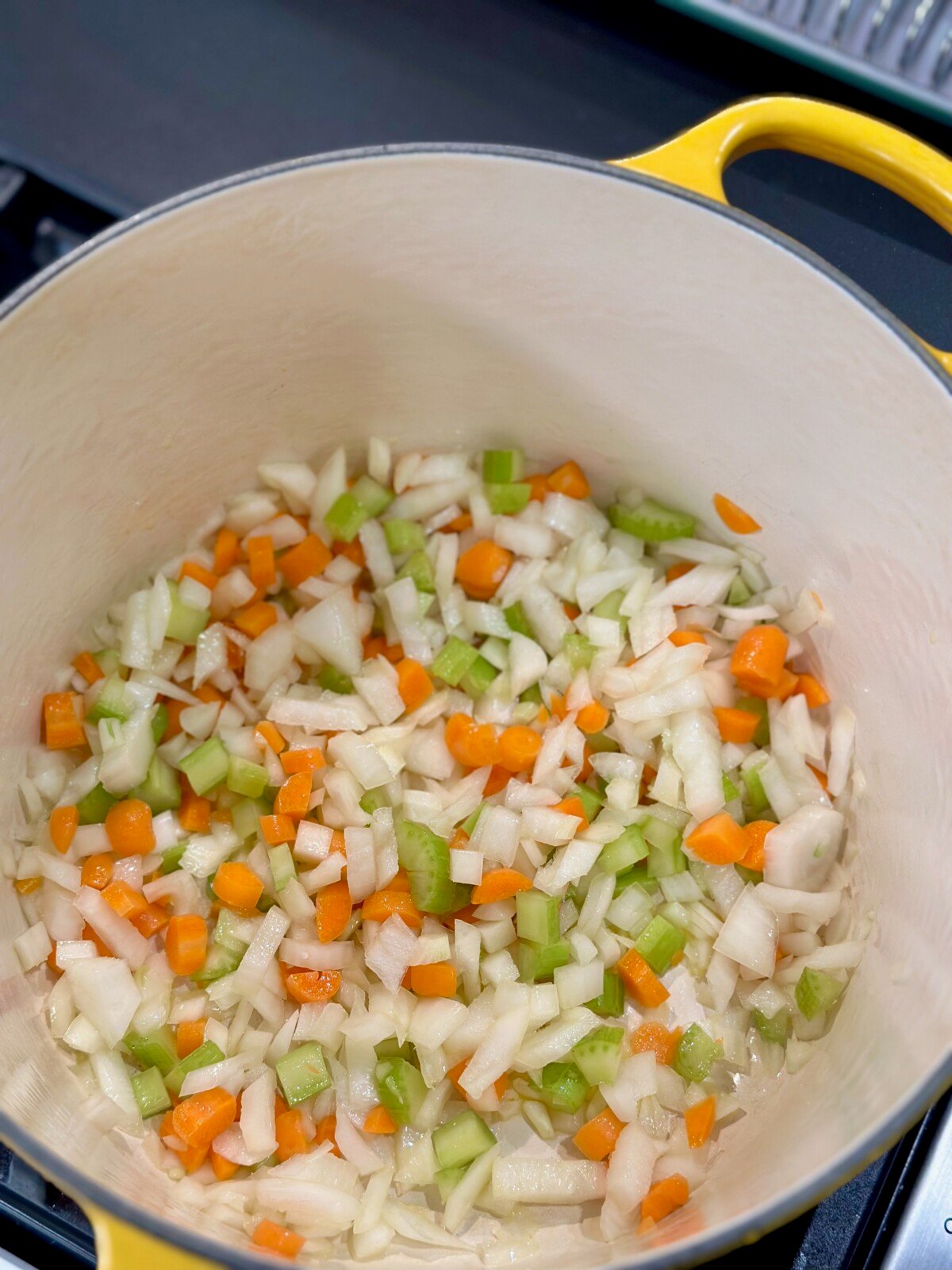 Yellow Dutch Oven with onions, celery, and carrots