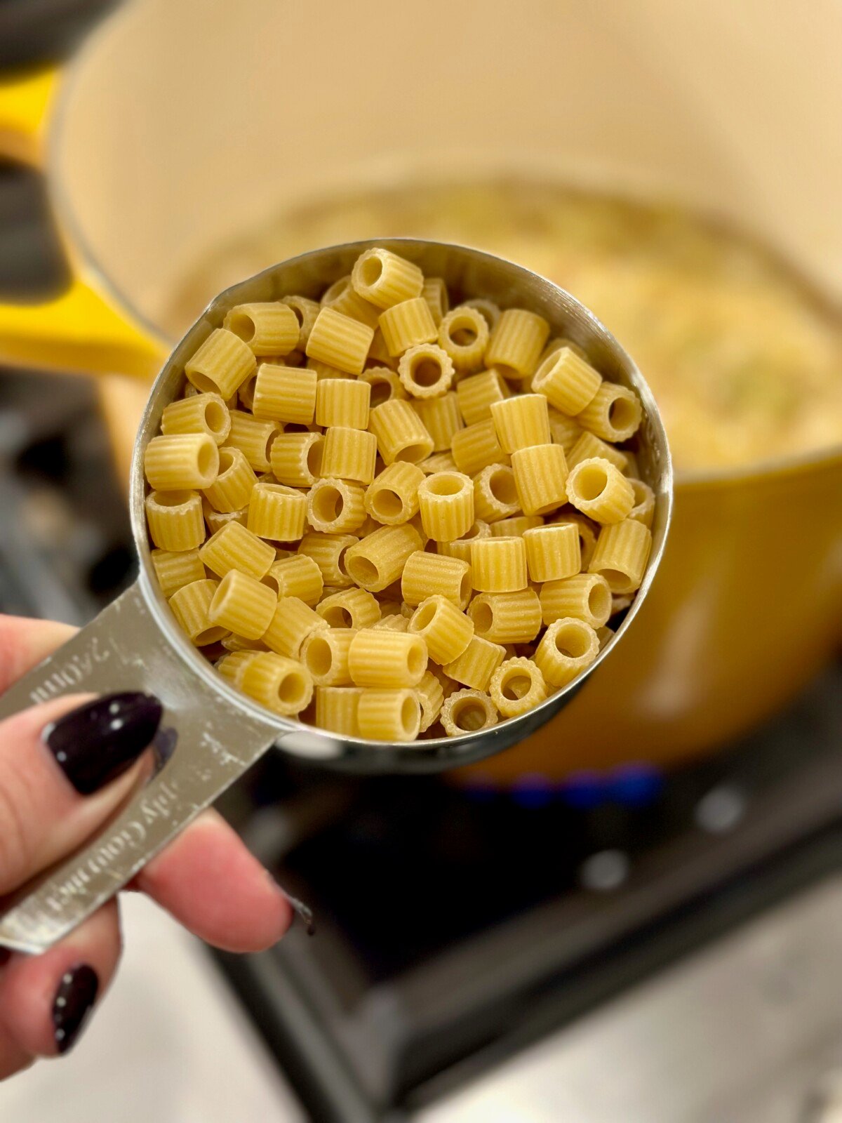 Measuring cup with uncooked ditalini pasta