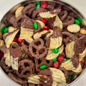 Tin of chocolate covered potato chips, chocolate covered pretzels, mini peanut butter sandwich crackers, honey roasted peanuts, mini reese's, and holiday M&M's