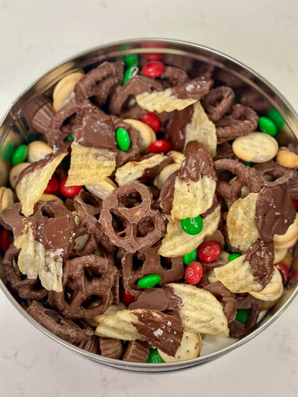 Tin of chocolate covered potato chips, chocolate covered pretzels, mini peanut butter sandwich crackers, honey roasted peanuts, mini reese's, and holiday M&M's