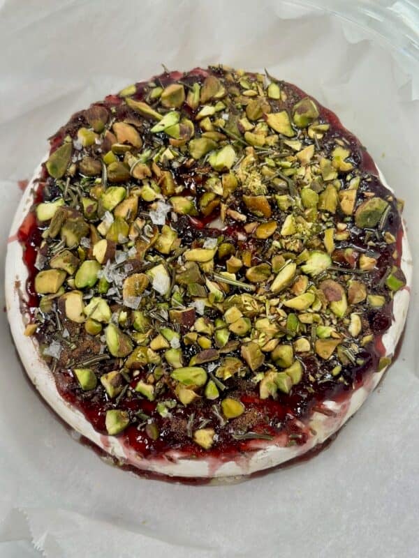Finished baked brie topped with pistachios and flaky salt after baking.