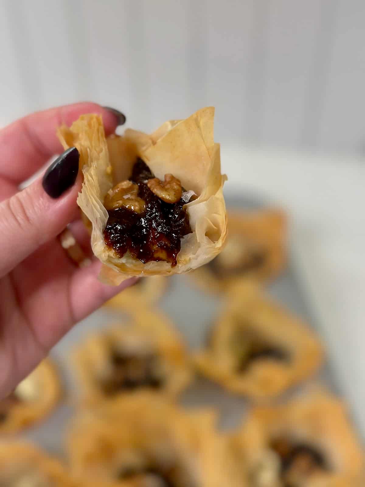 Bite showing creamy Boursin and fig filling inside phyllo cup.