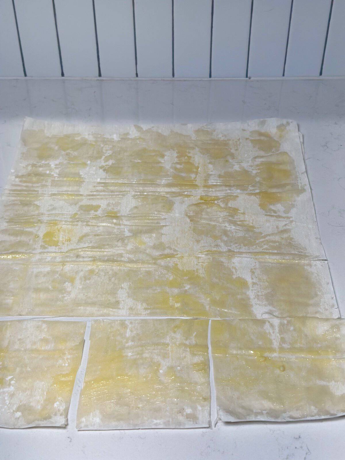 Phyllo dough sheets brushed and layered for phyllo cups.