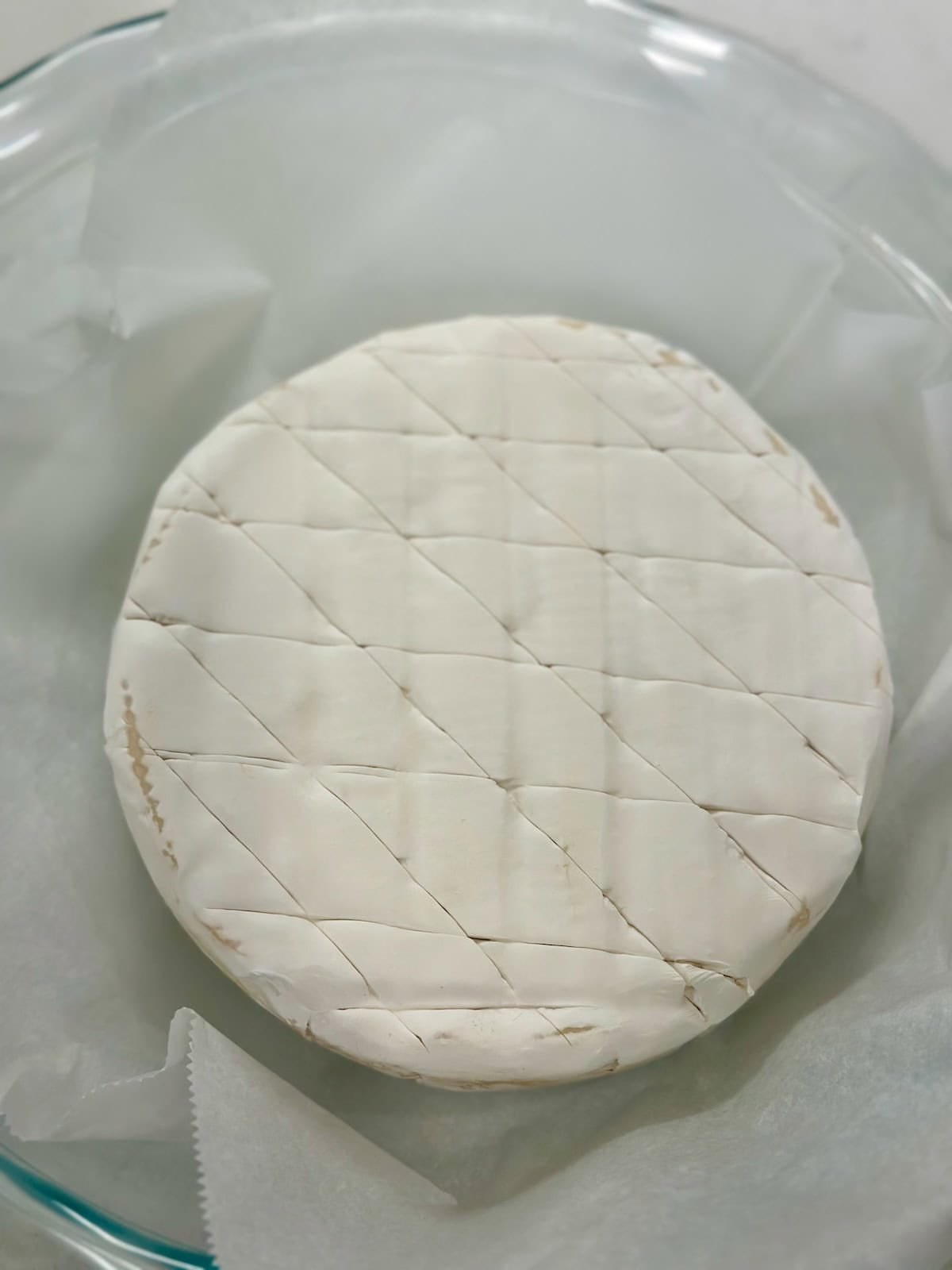Brie wheel scored with a criss cross pattern to help it bake evenly.