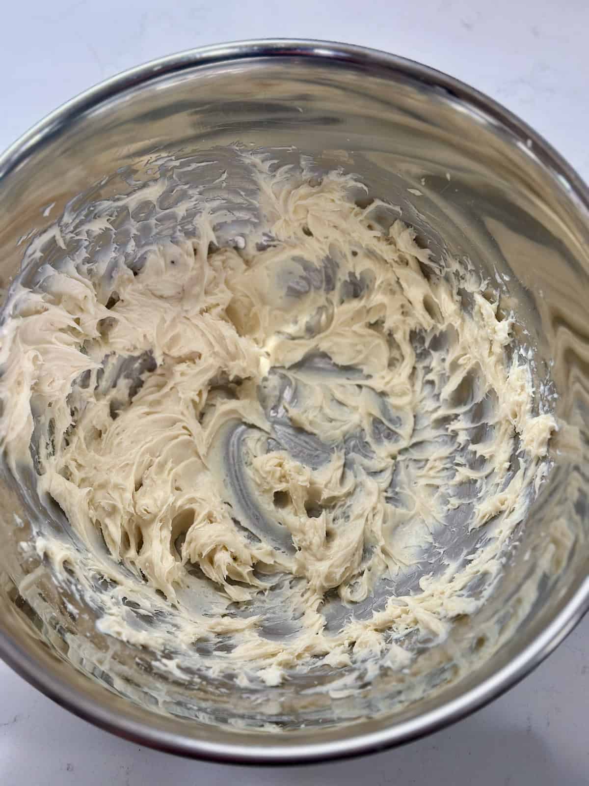 Cream cheese mixture beaten until smooth and fluffy in a metal bowl.